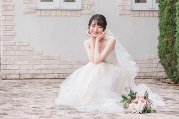 結婚式場のガーデンでウェディングフォトを撮る花嫁・新婦の女性
