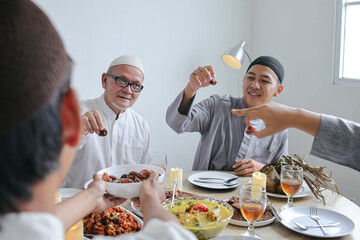 Portrait Of Young Muslim Man Sharing Dates Fruit to His Family During Eid Al Fitr Moment