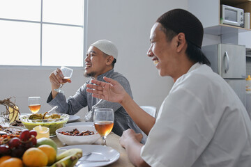 Portrait Of Two Young Asian Muslim Man Talking And Laughing Together With His Family on Ramadan Moment