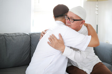 Fototapeta premium Muslim Family Forgiving Each Other. Grandfather Embrace His Son On Eid Al Fitr