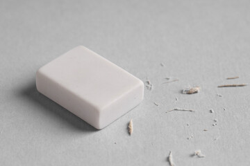 One eraser and scraps on grey background, closeup