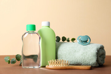 Baby oil and bath accessories on color background