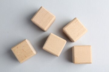 Blank wooden cubes on light grey background, flat lay