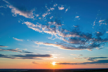A beautiful sunset sky with scattered clouds creating a colorful view over the horizon
