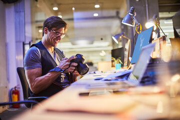 Young male photographer working in the office
