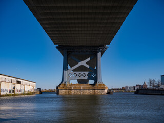 Underneath the Ben Franklin Suspension Bridge spanning the Delaware River from Camden NJ to Philadelphia PA looking across thre river towards Camden NJ