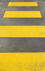 Fototapeta premium Close-up of yellow stripes of a crosswalk pedestrian crossing