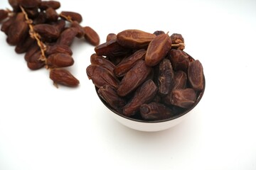 Dried dates fruits in ceramic bowl isolated on white background.