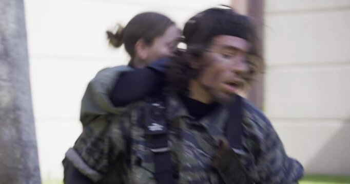 Soldier's face in pain as woman kicks knife into his stomach, steady cam shot