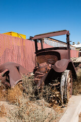 Front view of the remains of an antique Model T flatbed truck.