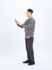 スマホを使うミドルエイジ男性の全身写真