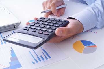 電卓でビジネスの計算をしている男性