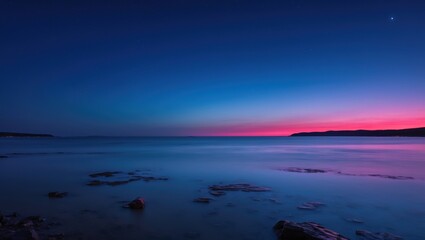 Fototapeta premium A tranquil coastal scene featuring smooth water reflecting vibrant hues of sunset with stars visible in a clear sky