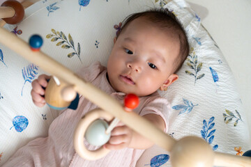 A 5-month-old newborn baby is happily playing with toys.