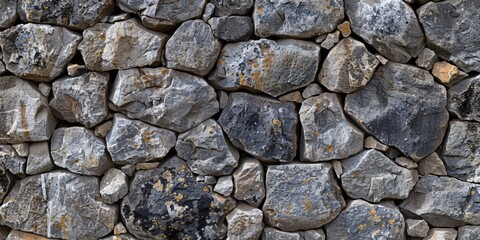 Fototapeta premium Textured stone wall with varied gray tones