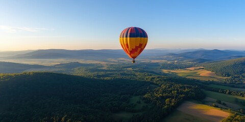 Fototapeta premium Another stunning hot air balloon gracefully glides over a picturesque landscape, showcasing the breathtaking panoramic views from an aerial perspective.