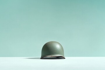 vintage military helmet rests quietly on plain white surface evoking memories of past bravery and sacrifices offering