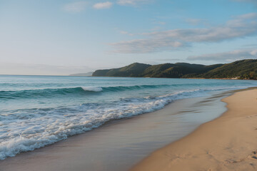 Obraz premium Crystal Clear Ocean Waves Washing Onto a Peaceful Sandy Beach