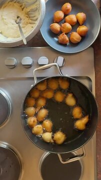 overhead view of preparing food, Fritule (fritters) Croatian mini doughnuts frying in oil