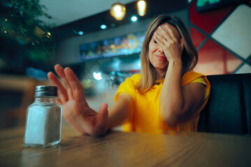 Woman Feeling Sick Refusing More Salt In a Restaurant. Person reducing sodium intake while dining out in a diner 