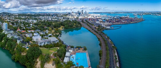 Panoramic aerial view of Auckland, New Zealand. Cityscape, harbor, and swimming pool visible. Shipping containers and city buildings are prominent. PARNELL, AUCKLAND, NEW ZEALAND