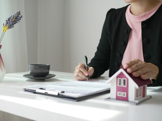 Beautiful real estate agent signs documents and gives home insurance advice Create a home purchase insurance contract to approve the purchase for the customer