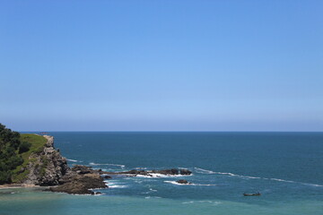 Serene Coastal Landscape with Gentle Waves and a Small Fishing Boat