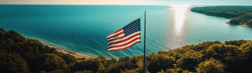 A stunning aerial view of the American flag waving in front of Lake Michigan, with lush green forests and blue waters stretching into the distance.