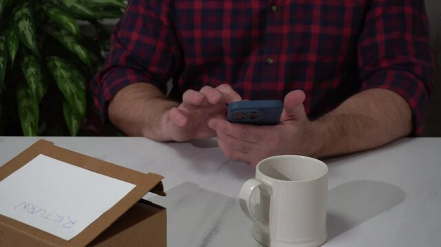 Man managing online return request using smartphone at home