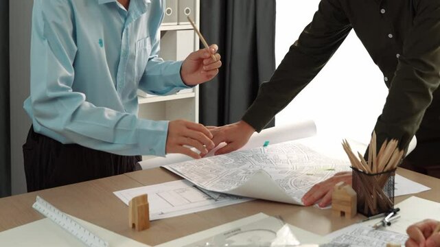 Professional engineer measuring the blueprint. Professional engineer working architectural project at studio on a table with yellow helmet and architectural equipment scatter around. Delineation.