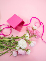 Mother day gift. Pastel color fresh buttercups bouquet and an open gift box on pink