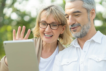 Technology connect and modern elderly lifestyles concept. Aged senior couple waving hands greeting...