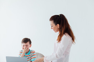 Female teacher helping boy on laptop to play