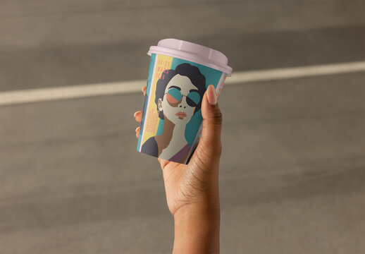 Female hand holds a disposable takeaway paper cup with a lid, ready for a hot beverage on the go. PSD template mockup ready for your Design