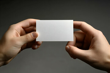 Close-up studio shot of a person holding a blank business card mock-up