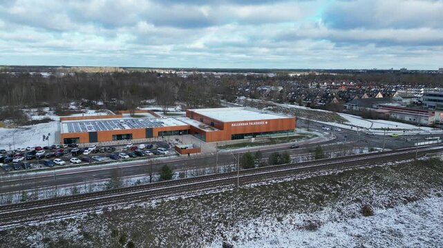 Indoor swimming pool with solar panels surrounded by snow and suburban homes in Falkensee Germany. Spectacular aerial view flight panorama overview drone
