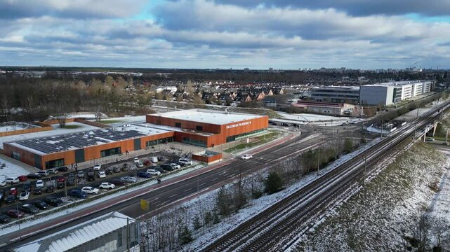 Indoor swimming pool with solar panels surrounded by snow and suburban homes in Falkensee Germany. Amazing aerial view flight static tripod hovering drone