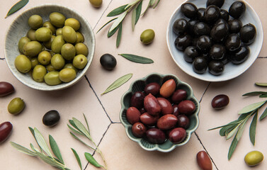 Assorted olives in ceramic bowls with leaves