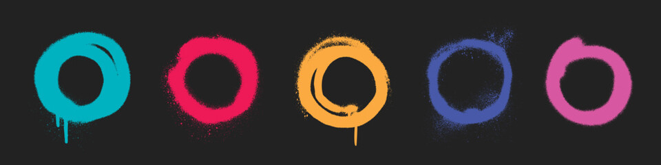 Fototapeta premium Spray paint circles in vibrant neon colors on black background. Distinct ring shapes with bright tones, drips and splatters, particle effects. Urban graffiti elements for street art graphic design.