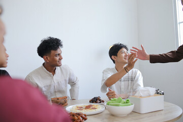 Muslim Friends Shaking Each Other Hands in Dining Table During Ramadan Celebration