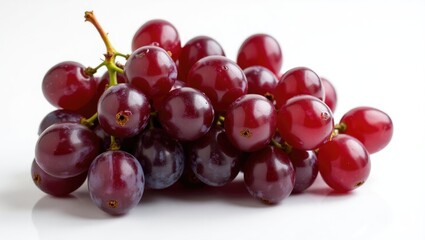 Fototapeta premium Dense bunch of deep red grapes against a light background.