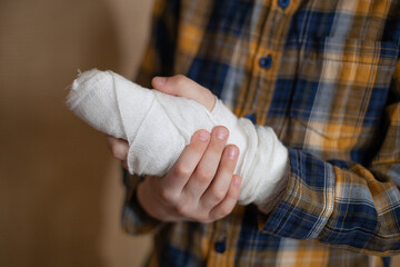 Close up of boy's hand in gypsum cast because fractured main phalanx of third finger. Childhood...