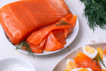 Cold smoked trout fillet on ceramic plate on white table