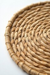 Obraz premium Close-up view of a meticulously handcrafted circular woven coaster, showcasing the intricate spiral pattern and natural beige tones of the fibers.
