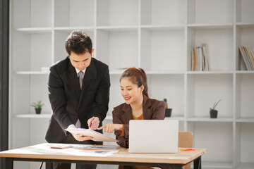 Male and female business people working in finance in an office.