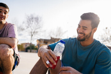 Basketball players resting and drinking energy drink after sport match