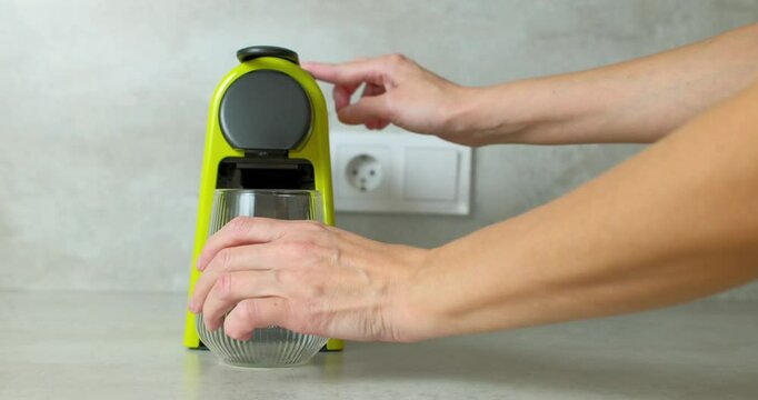 Woman Using a Green Coffee Machine at Home
