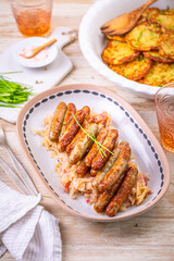 Nuremberg grilled small sausages with sauerkraut and crispy potato pancakes
