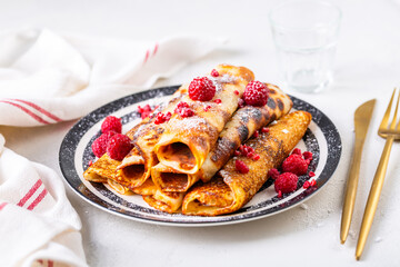 Homemade rolled pancakes, flapjacks filled with cream cheese with fresh berries