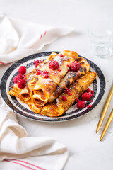 Homemade rolled pancakes, flapjacks filled with cream cheese with fresh berries